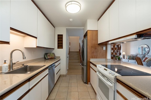 kitchen with white cabinets, sink, light tile patterned floors, and stainless steel appliances