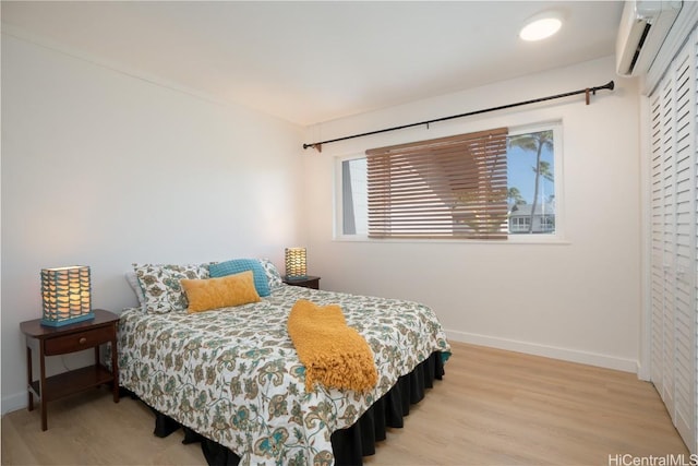 bedroom with a wall mounted AC and hardwood / wood-style floors