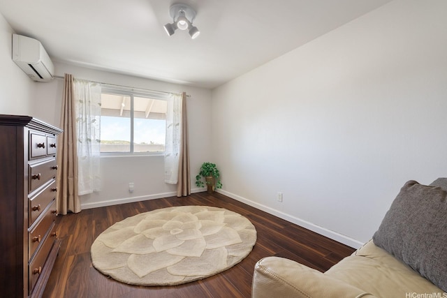 sitting room featuring an AC wall unit, baseboards, and dark wood-type flooring