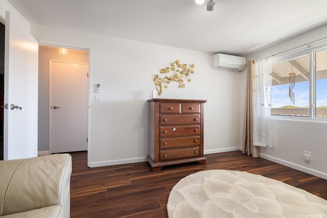 bedroom featuring baseboards, a wall unit AC, and dark wood finished floors