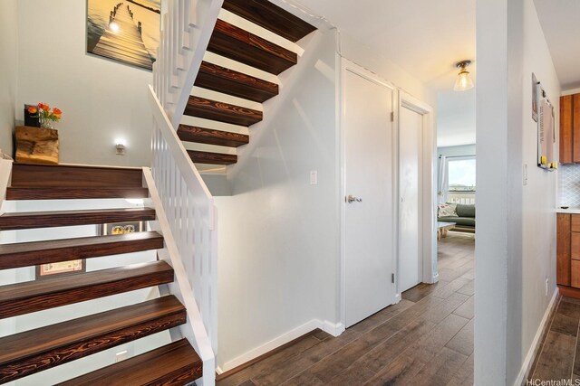 stairway featuring baseboards and wood finished floors