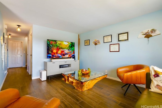 living area with a fireplace, baseboards, and wood finished floors