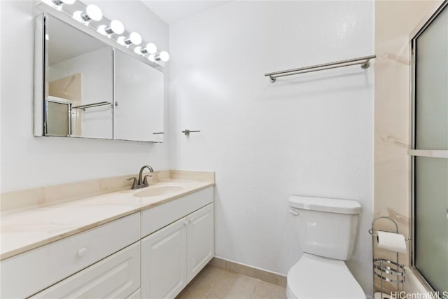 bathroom featuring toilet, tile patterned flooring, a shower with shower door, and vanity