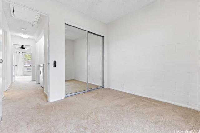 unfurnished bedroom featuring light colored carpet and a closet