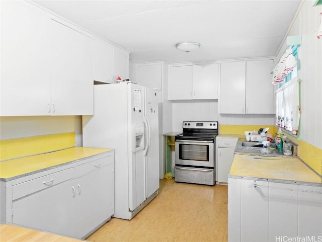 kitchen with light hardwood / wood-style floors, white cabinetry, white fridge with ice dispenser, and stainless steel range with electric cooktop