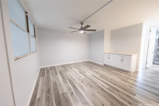 unfurnished living room featuring ceiling fan and light hardwood / wood-style floors