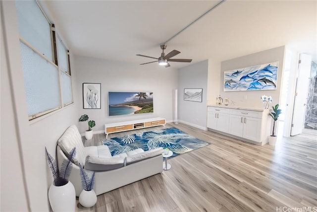 living room with ceiling fan and light wood-type flooring