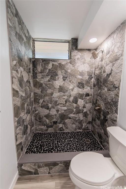 bathroom with toilet and tiled shower