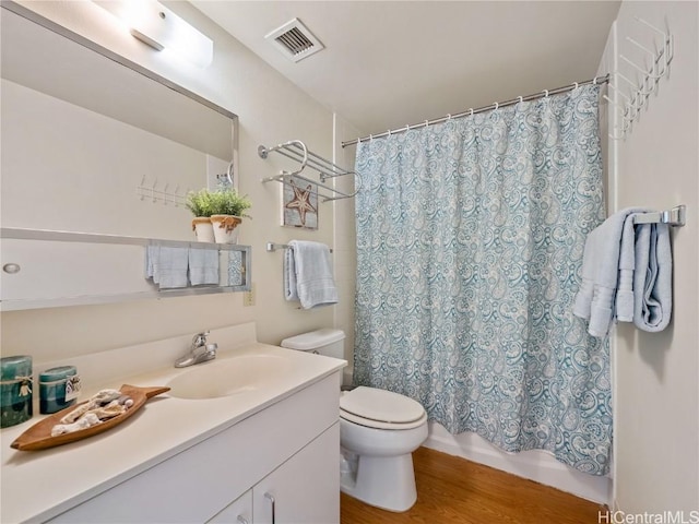 bathroom with toilet, a shower with shower curtain, hardwood / wood-style flooring, and vanity