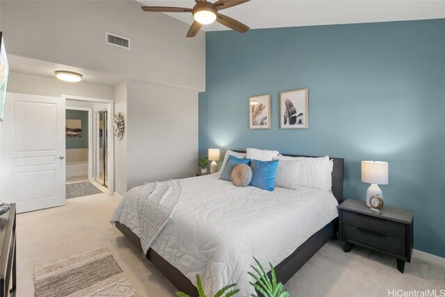 bedroom featuring vaulted ceiling, light carpet, ceiling fan, and ensuite bathroom