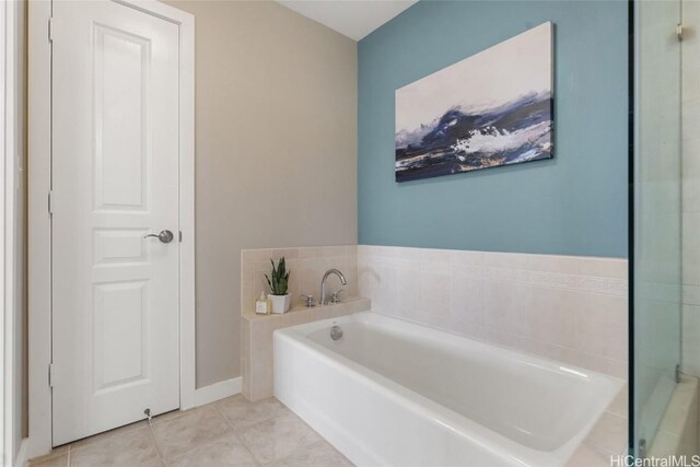 bathroom with a bath and tile patterned flooring