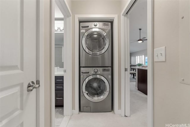 clothes washing area with light colored carpet and stacked washing maching and dryer