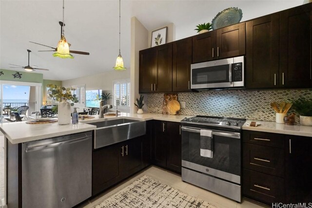 kitchen with pendant lighting, appliances with stainless steel finishes, kitchen peninsula, and sink