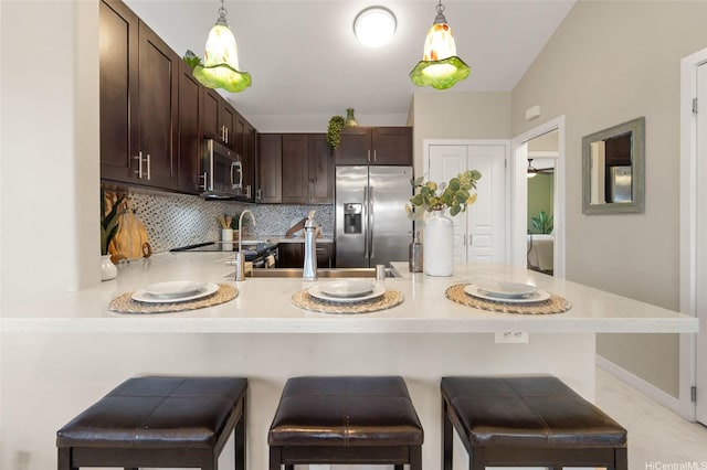 92-1001 Aliinui Dr Unit 25C, Kapolei, HI 96707 - kitchen featuring stainless steel appliances, dark brown cabinetry, light countertops, a peninsula, and tasteful backsplash