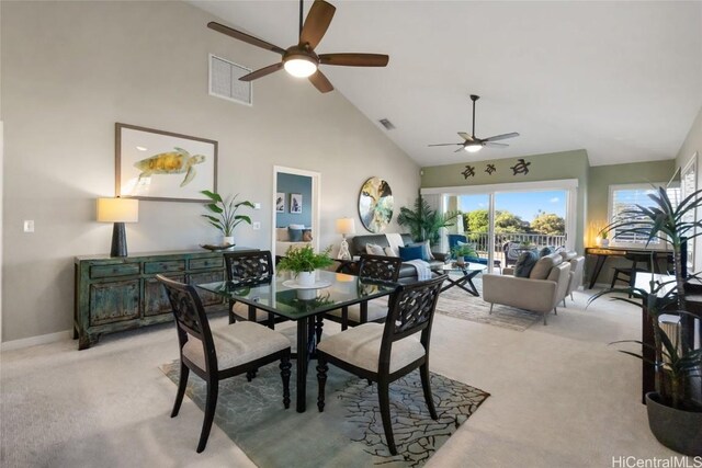 dining area with light carpet and high vaulted ceiling