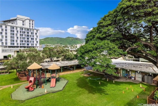 exterior space with a mountain view, a yard, and a playground