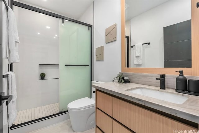 bathroom with walk in shower, vanity, and toilet