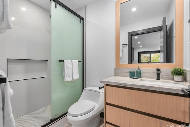 bathroom with toilet, vanity, and walk in shower