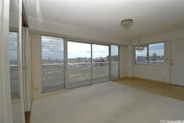 unfurnished room with an inviting chandelier and a textured ceiling