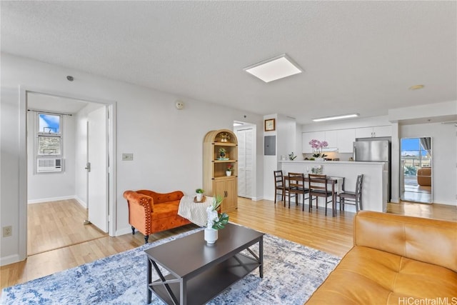 living room with a textured ceiling and light hardwood / wood-style floors