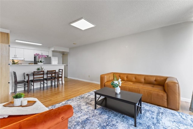 living room with a textured ceiling and light hardwood / wood-style floors