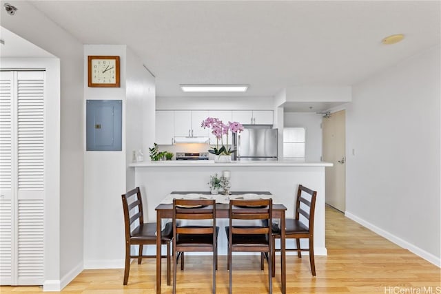 dining space featuring light hardwood / wood-style flooring and electric panel