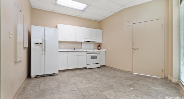 kitchen with white cabinets, a drop ceiling, and white appliances