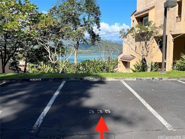 view of car parking featuring a water view