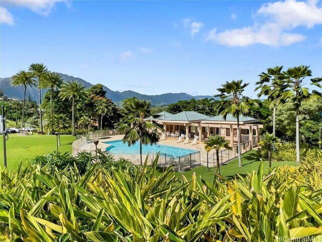 view of swimming pool featuring a mountain view, a yard, and a patio area