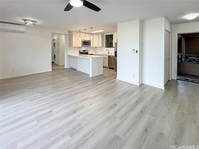 kitchen featuring a wall mounted air conditioner, decorative light fixtures, kitchen peninsula, stainless steel appliances, and light hardwood / wood-style flooring