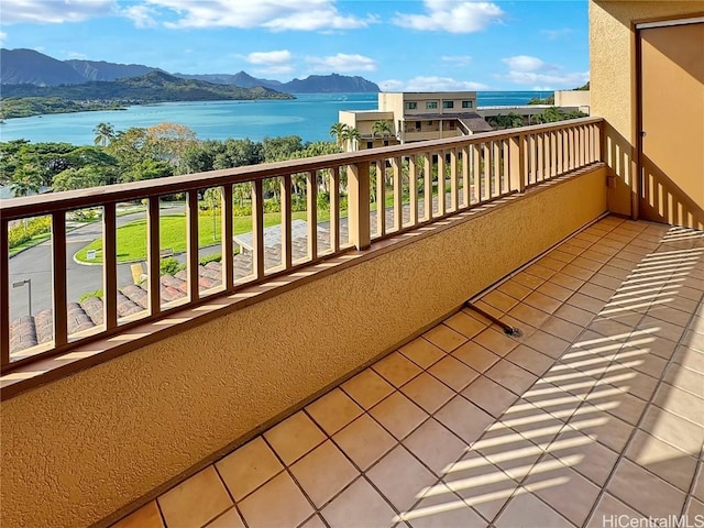 balcony featuring a water and mountain view