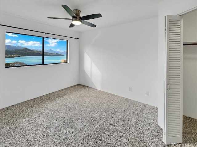 unfurnished bedroom with carpet floors, a closet, and ceiling fan