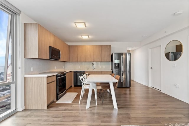 kitchen featuring sink, appliances with stainless steel finishes, light hardwood / wood-style flooring, and tasteful backsplash