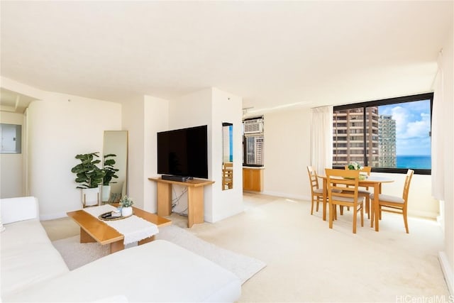 living room featuring light carpet, electric panel, and a wall unit AC