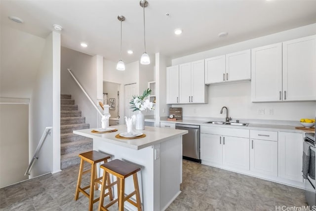 kitchen featuring pendant lighting, sink, stainless steel appliances, white cabinets, and a kitchen island