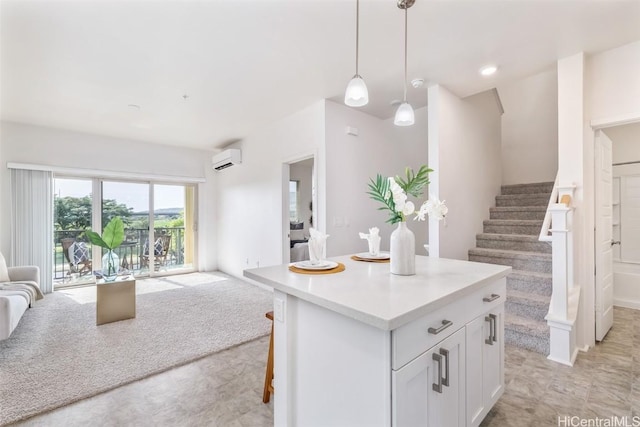 kitchen featuring decorative light fixtures, white cabinetry, a kitchen bar, a center island, and a wall unit AC