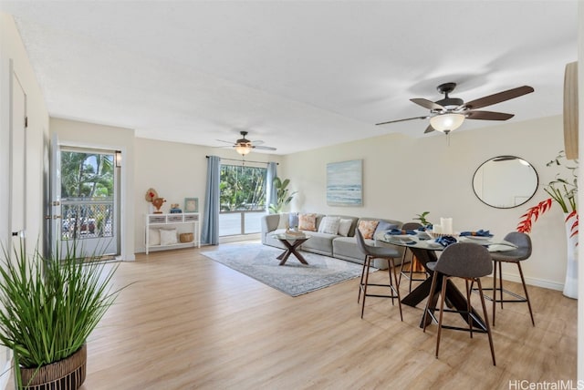 living area with ceiling fan, light wood-type flooring, and baseboards