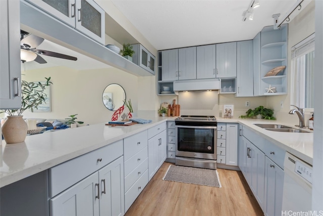 kitchen featuring sink, stainless steel range with electric cooktop, ceiling fan, white dishwasher, and light wood-type flooring