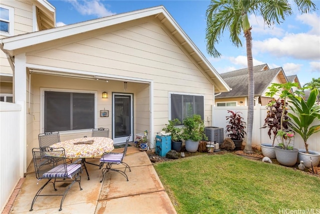 back of property with a lawn, central AC, and a patio