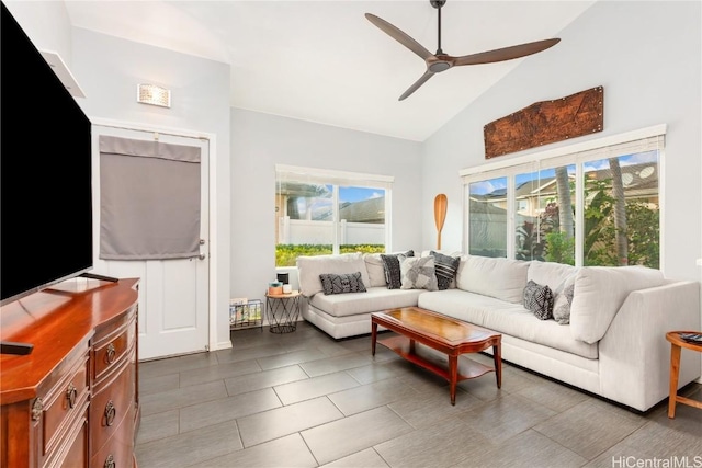 tiled living room with ceiling fan and high vaulted ceiling