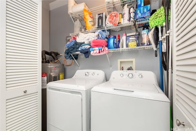 washroom with water heater and washing machine and clothes dryer