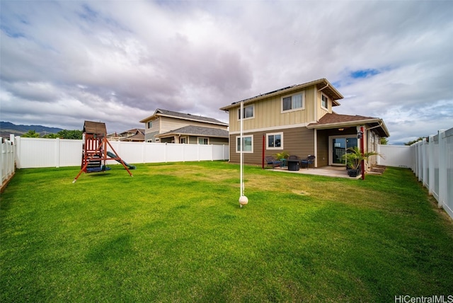 back of property with a yard, a playground, and a patio