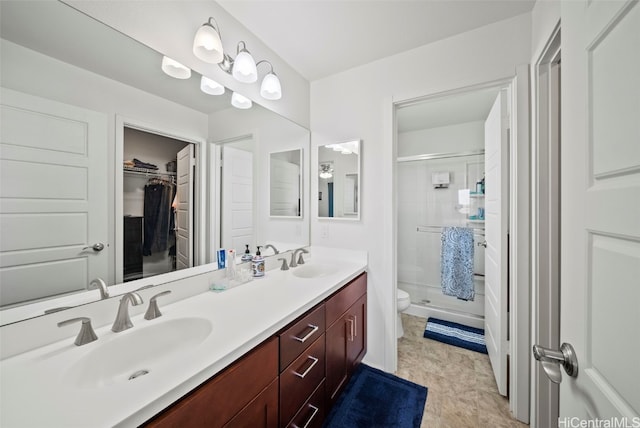 bathroom featuring vanity, toilet, and a shower with shower door