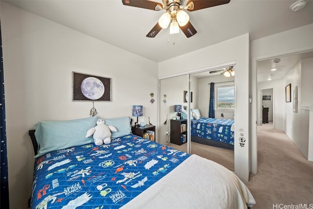 bedroom with light colored carpet, ceiling fan, and a closet