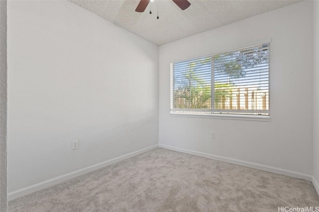 spare room with ceiling fan, light colored carpet, and a textured ceiling