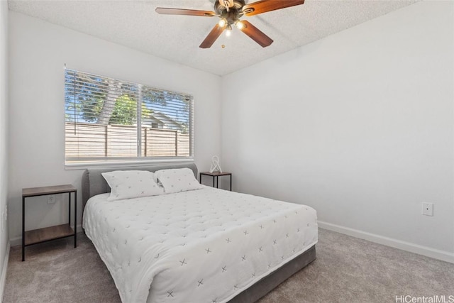 bedroom with ceiling fan, carpet, and a textured ceiling