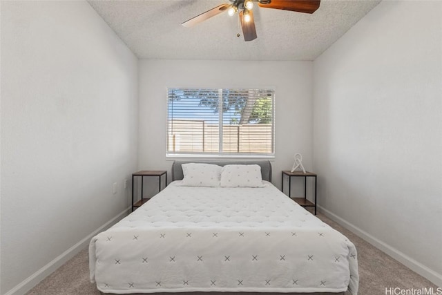 carpeted bedroom featuring a textured ceiling and ceiling fan