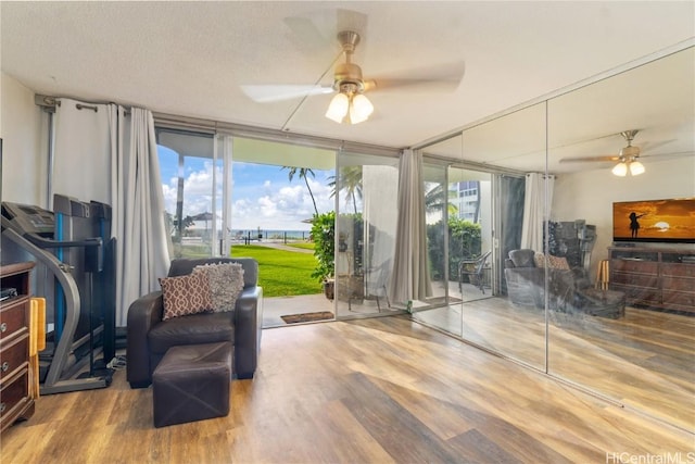 living area featuring a healthy amount of sunlight, hardwood / wood-style floors, and ceiling fan