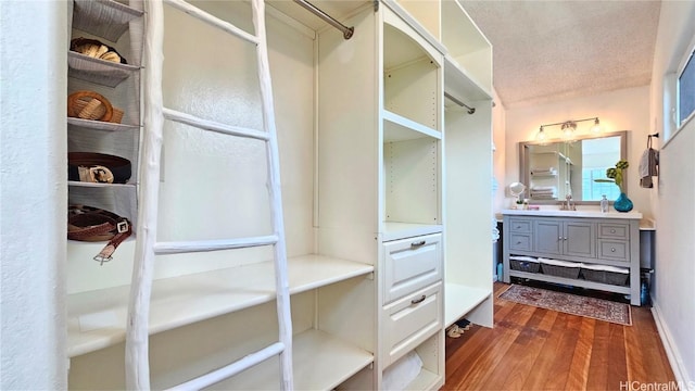 walk in closet featuring sink and dark hardwood / wood-style flooring