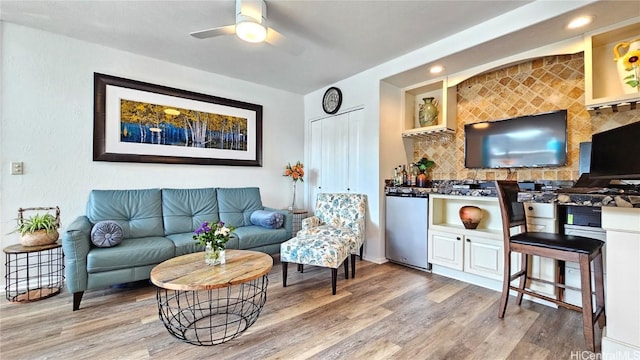 living room featuring ceiling fan and hardwood / wood-style floors